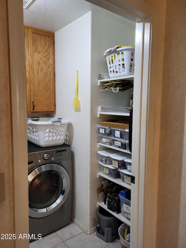 laundry room with baseboards, washer / clothes dryer, cabinet space, and tile patterned floors