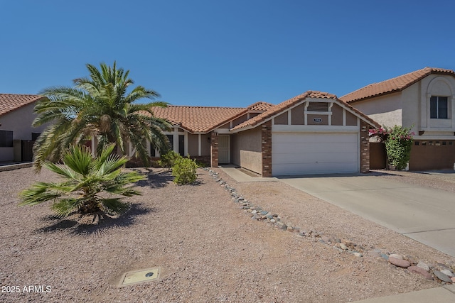 5911 E Evergreen St, Mesa, AZ 85205 - view of front of house with a tiled roof, driveway, stucco siding, and an attached garage