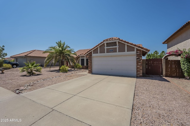 5911 E Evergreen St, Mesa, AZ 85205 - view of front facade with concrete driveway, an attached garage, a tiled roof, and stucco siding