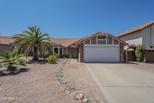 5911 E Evergreen St, Mesa, AZ 85205 - view of front of property featuring a garage, concrete driveway, a tile roof, and stucco siding