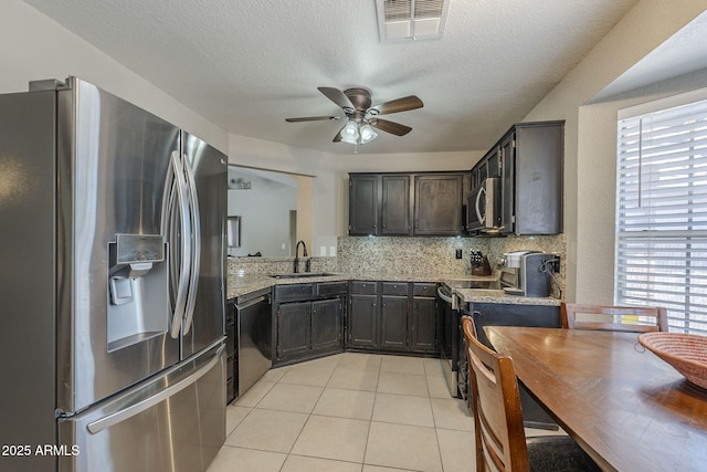5911 E Evergreen St, Mesa, AZ 85205 - kitchen with appliances with stainless steel finishes, ceiling fan, light tile patterned flooring, backsplash, and light stone countertops