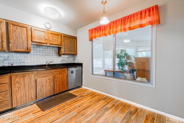 kitchen with pendant lighting, sink, backsplash, dishwasher, and light hardwood / wood-style floors