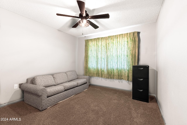 living area featuring carpet, a textured ceiling, and ceiling fan