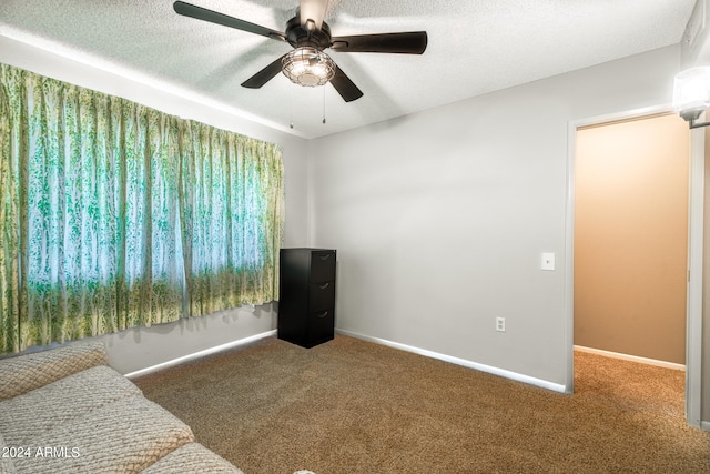 carpeted bedroom with ceiling fan and a textured ceiling