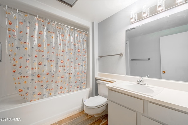 full bathroom featuring vanity, hardwood / wood-style floors, toilet, and shower / tub combo with curtain