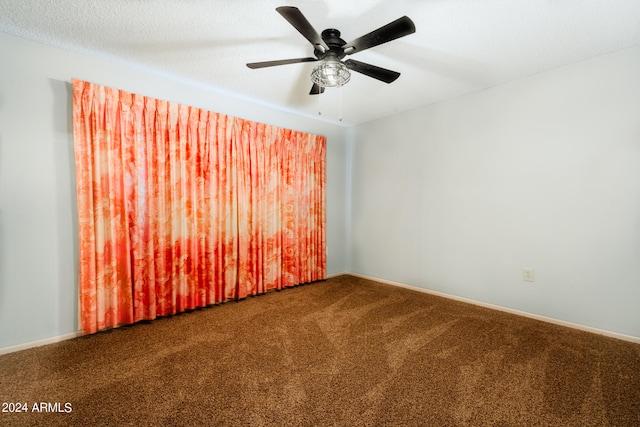 carpeted empty room featuring ceiling fan and a textured ceiling