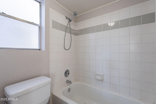 bathroom featuring tiled shower / bath combo and toilet