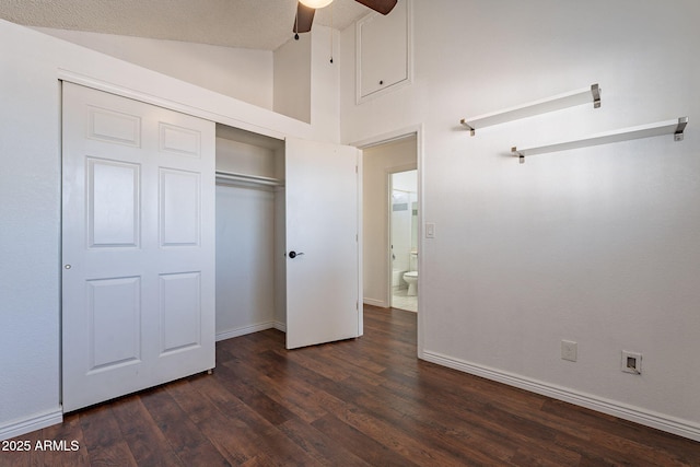 unfurnished bedroom with dark wood-type flooring, ceiling fan, high vaulted ceiling, and a closet