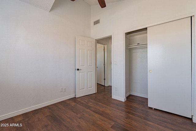 unfurnished bedroom with ceiling fan, high vaulted ceiling, dark hardwood / wood-style flooring, and a closet