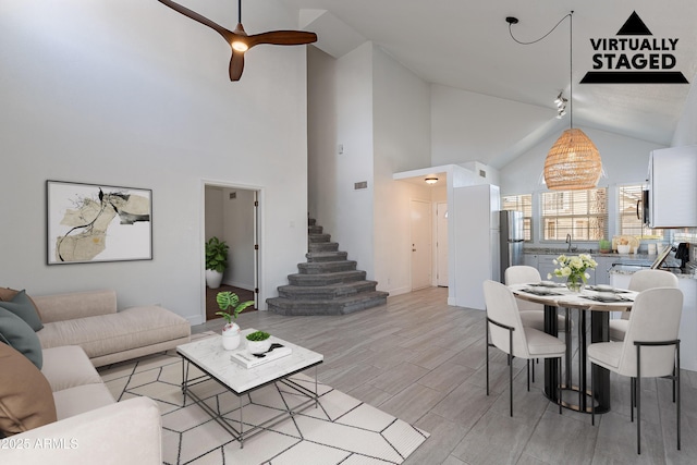 living room with ceiling fan, sink, and vaulted ceiling