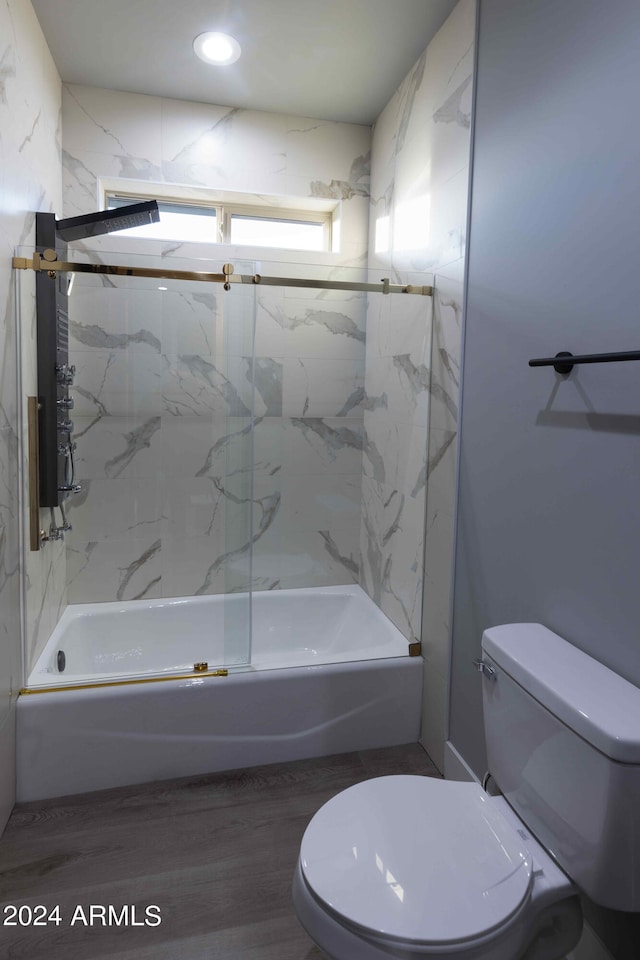 bathroom featuring toilet, tiled shower / bath, and hardwood / wood-style floors