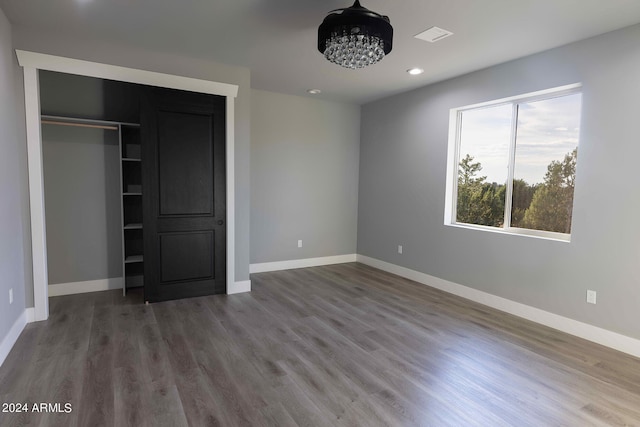 unfurnished bedroom with a closet and hardwood / wood-style floors