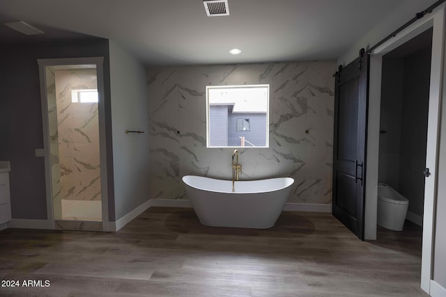 bathroom featuring toilet, hardwood / wood-style floors, and shower with separate bathtub