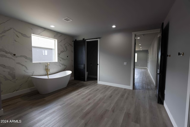 bathroom featuring hardwood / wood-style flooring and a bath