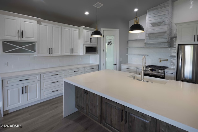 kitchen featuring stainless steel appliances, backsplash, pendant lighting, white cabinets, and dark hardwood / wood-style flooring