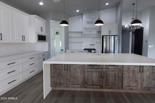 kitchen with a large island with sink, lofted ceiling, appliances with stainless steel finishes, and white cabinets