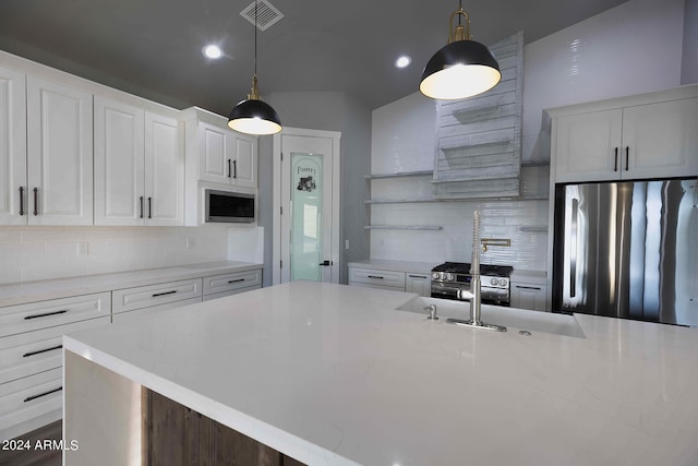 kitchen with tasteful backsplash, an island with sink, white cabinetry, stainless steel appliances, and decorative light fixtures