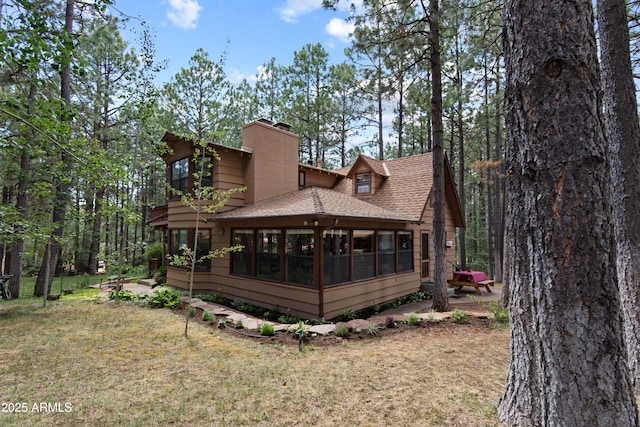 3910 Larson Loop, Forest Lakes, AZ 85931 - back of property with roof with shingles, a sunroom, a chimney, and a lawn