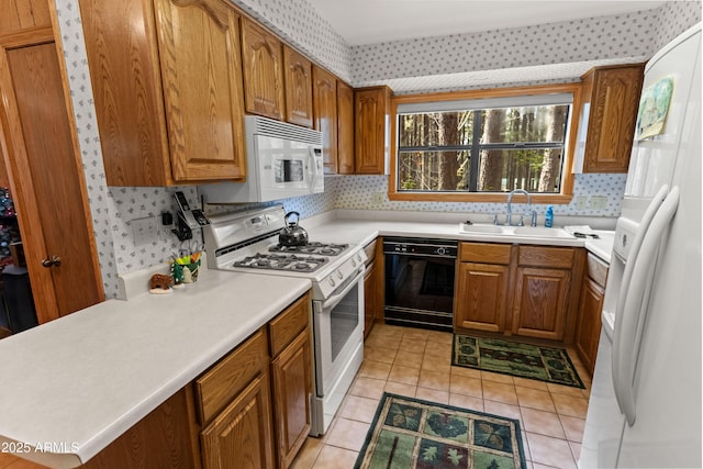 3910 Larson Loop, Forest Lakes, AZ 85931 - kitchen with white appliances, brown cabinetry, wallpapered walls, light countertops, and light tile patterned floors