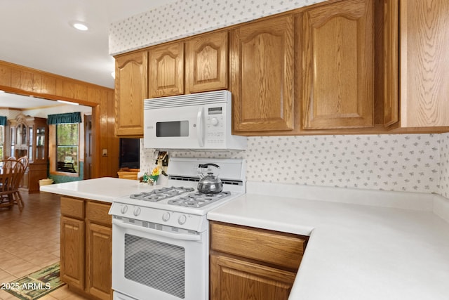 3910 Larson Loop, Forest Lakes, AZ 85931 - kitchen with white appliances, light countertops, brown cabinets, and wood walls
