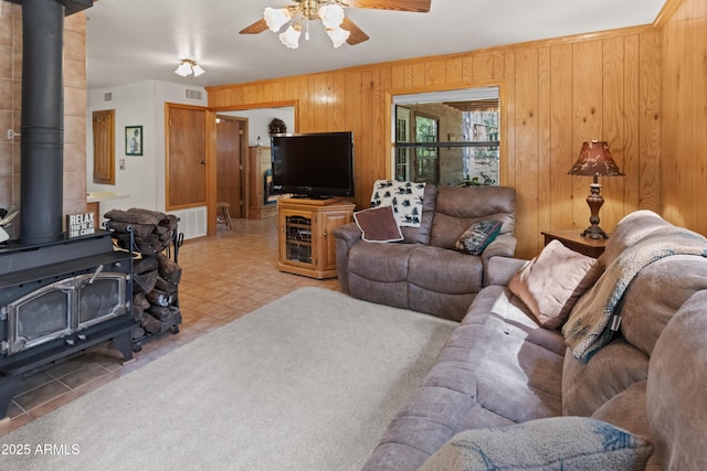 3910 Larson Loop, Forest Lakes, AZ 85931 - living room with a wood stove, a ceiling fan, and wooden walls