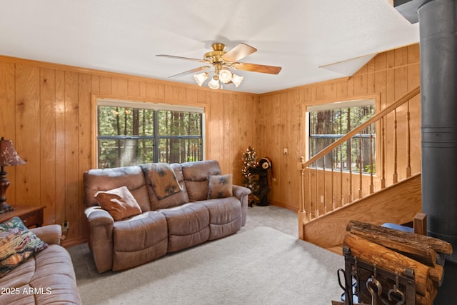 3910 Larson Loop, Forest Lakes, AZ 85931 - living room featuring plenty of natural light, a ceiling fan, a wood stove, and wood walls