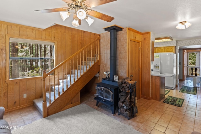 3910 Larson Loop, Forest Lakes, AZ 85931 - stairs featuring tile patterned floors, a wood stove, wood walls, and a ceiling fan