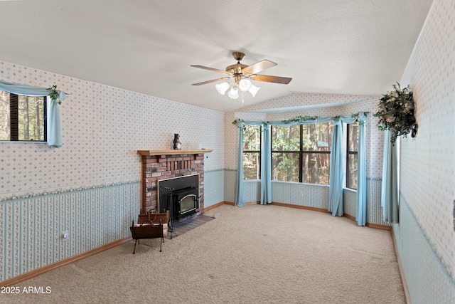 3910 Larson Loop, Forest Lakes, AZ 85931 - living room featuring wallpapered walls, vaulted ceiling, ceiling fan, carpet, and a wood stove