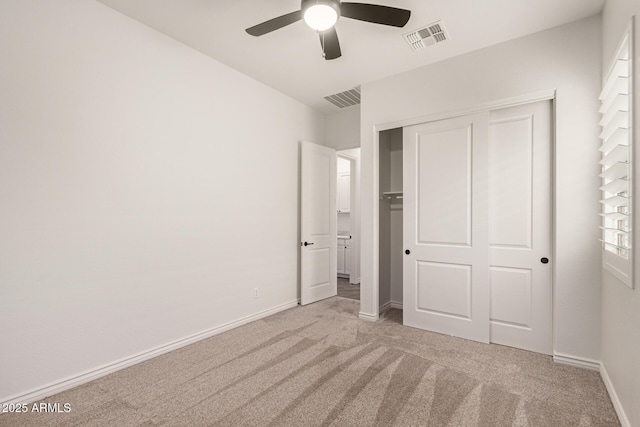 unfurnished bedroom featuring carpet floors, a closet, baseboards, and a ceiling fan