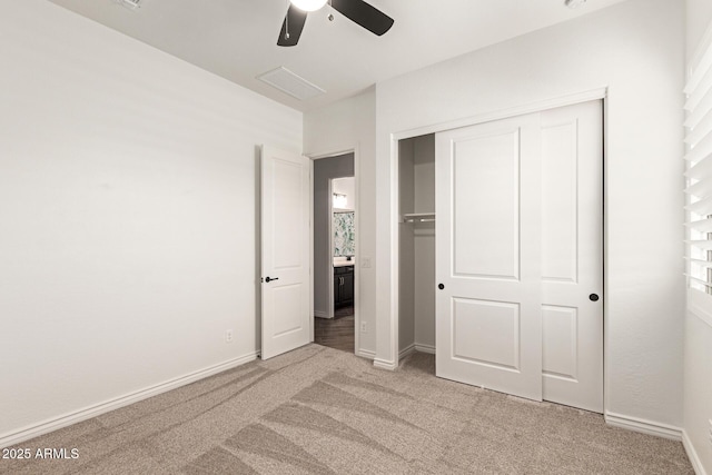 unfurnished bedroom with light colored carpet, baseboards, a closet, and ceiling fan