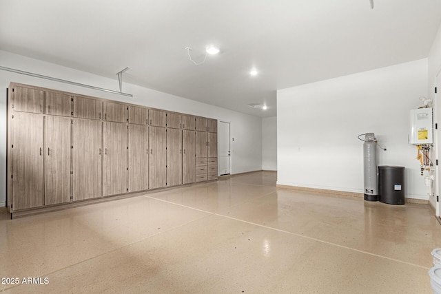 garage with baseboards and water heater