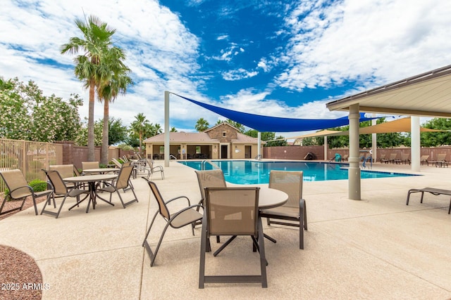 community pool featuring fence, a patio, and outdoor dining area