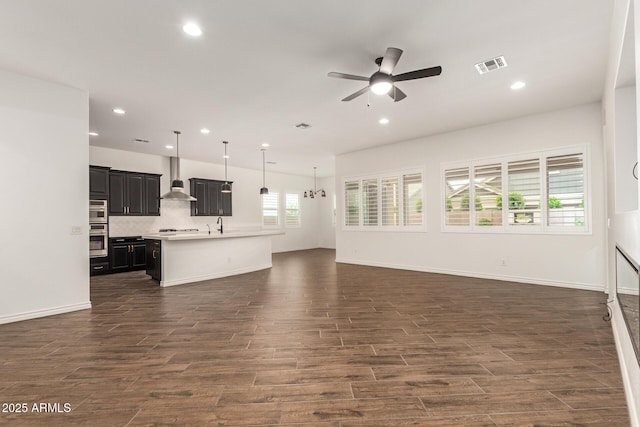 unfurnished living room with ceiling fan, dark wood-type flooring, recessed lighting, and baseboards