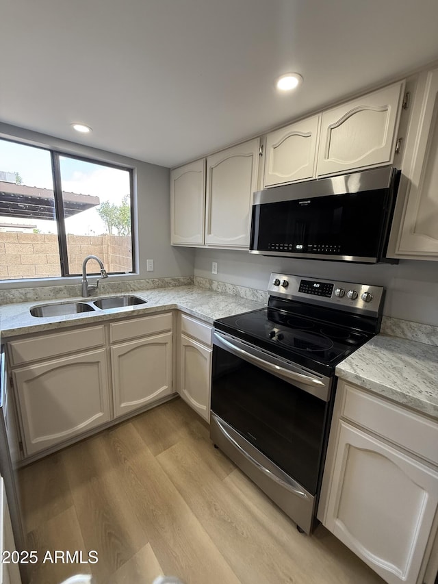 170 E Guadalupe Rd Unit 173, Gilbert, AZ 85234 - kitchen featuring stainless steel appliances, a sink, light wood finished floors, recessed lighting, and white cabinets