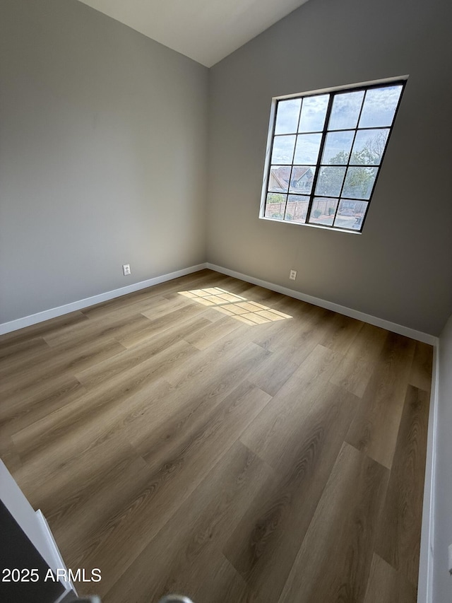 170 E Guadalupe Rd Unit 173, Gilbert, AZ 85234 - unfurnished room with vaulted ceiling, wood finished floors, and baseboards