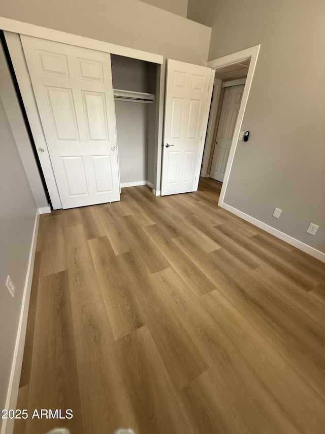 170 E Guadalupe Rd Unit 173, Gilbert, AZ 85234 - unfurnished bedroom with wood finished floors, a closet, and baseboards