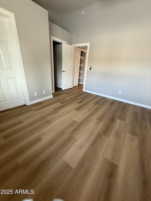 170 E Guadalupe Rd Unit 173, Gilbert, AZ 85234 - unfurnished bedroom with baseboards, wood finished floors, and a towering ceiling