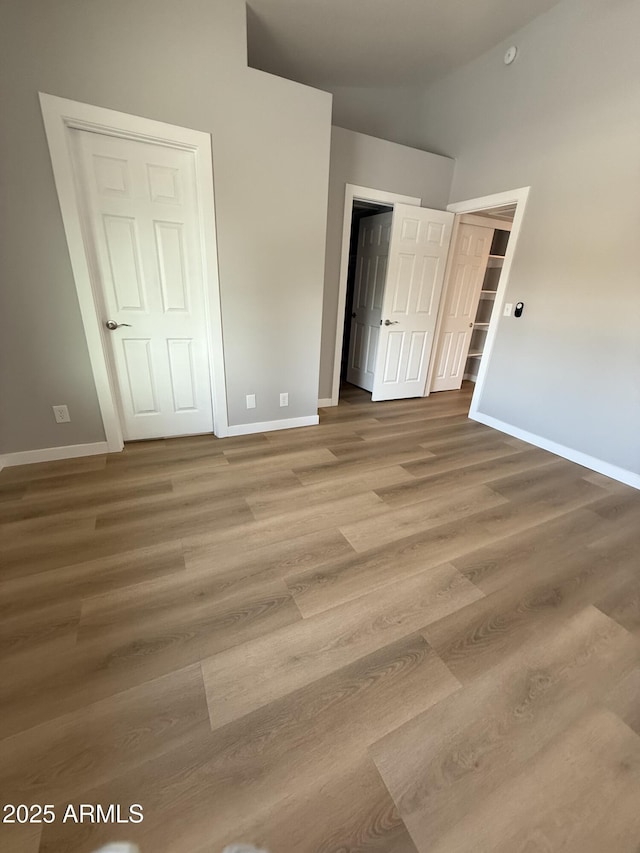 170 E Guadalupe Rd Unit 173, Gilbert, AZ 85234 - unfurnished bedroom with baseboards, wood finished floors, and high vaulted ceiling