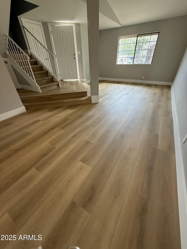 170 E Guadalupe Rd Unit 173, Gilbert, AZ 85234 - unfurnished living room with wood finished floors, baseboards, and stairs