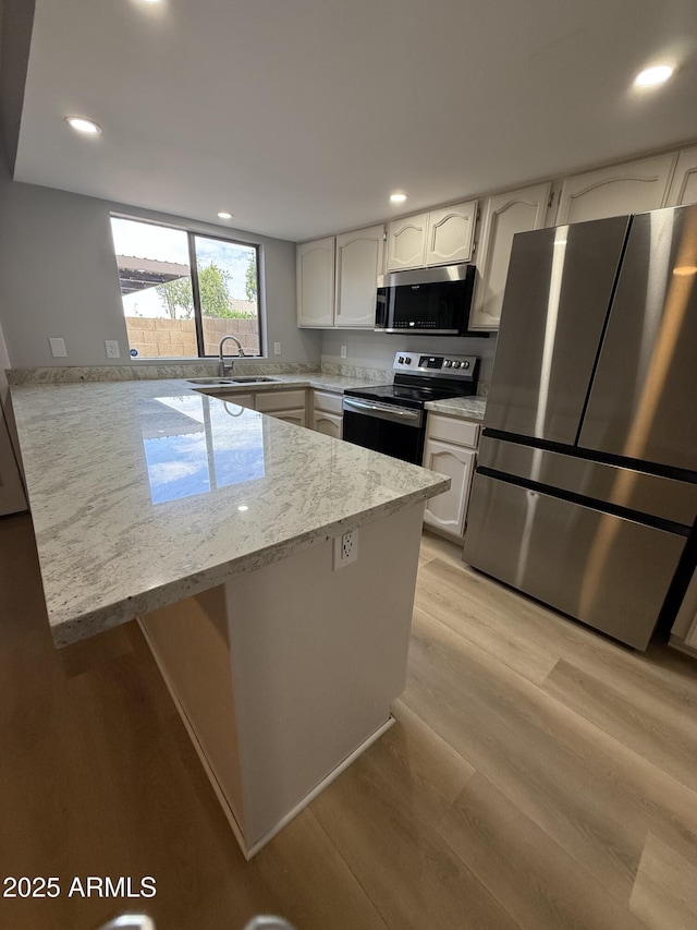 170 E Guadalupe Rd Unit 173, Gilbert, AZ 85234 - kitchen with appliances with stainless steel finishes, a sink, a peninsula, white cabinetry, and recessed lighting