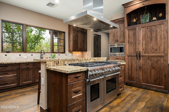 8454 E Leaning Rock Rd, Scottsdale, AZ 85266 - kitchen featuring dark wood finished floors, tasteful backsplash, visible vents, island exhaust hood, and stainless steel appliances