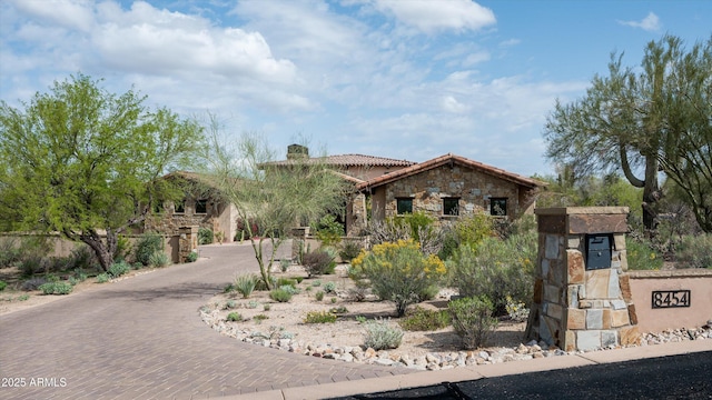 8454 E Leaning Rock Rd, Scottsdale, AZ 85266 - view of front facade featuring a tile roof, curved driveway, stone siding, and a chimney