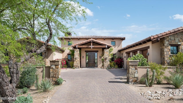 8454 E Leaning Rock Rd, Scottsdale, AZ 85266 - mediterranean / spanish-style home featuring stucco siding, stone siding, a tile roof, and decorative driveway