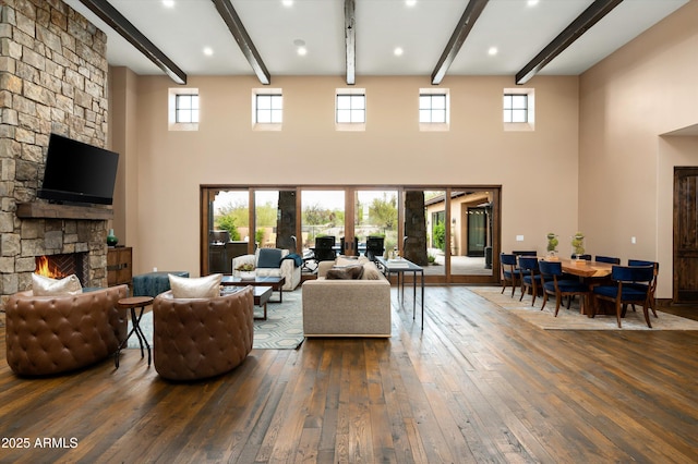 8454 E Leaning Rock Rd, Scottsdale, AZ 85266 - living area featuring wood-type flooring, beam ceiling, a stone fireplace, and a wealth of natural light