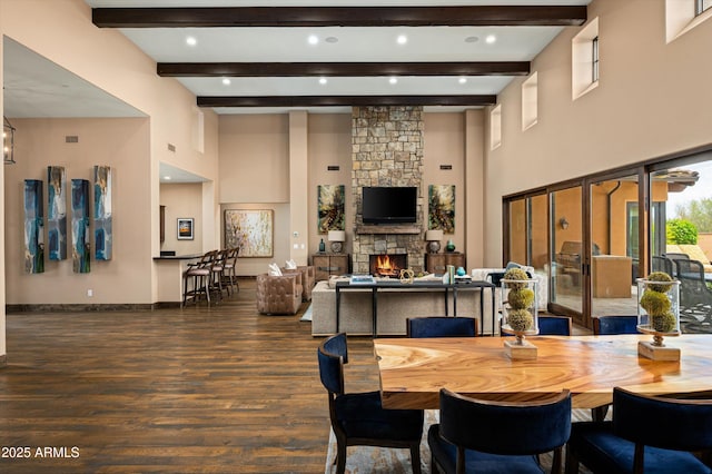 8454 E Leaning Rock Rd, Scottsdale, AZ 85266 - dining space featuring a towering ceiling, a stone fireplace, baseboards, beamed ceiling, and wood finished floors