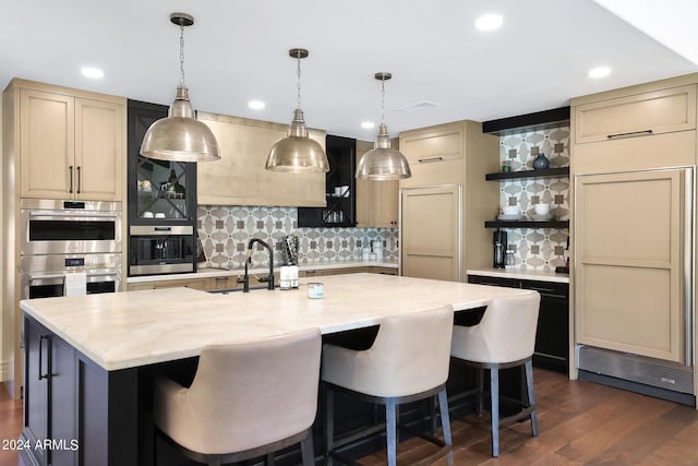 2421 E Montebello Ave, Phoenix, AZ 85016 - kitchen featuring an island with sink, open shelves, a breakfast bar, stainless steel double oven, and decorative backsplash