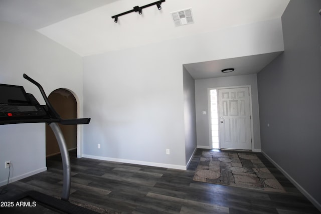 exercise room with dark wood-type flooring and lofted ceiling