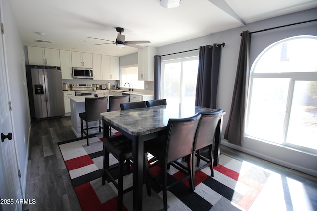 dining room featuring dark wood finished floors, visible vents, and a ceiling fan