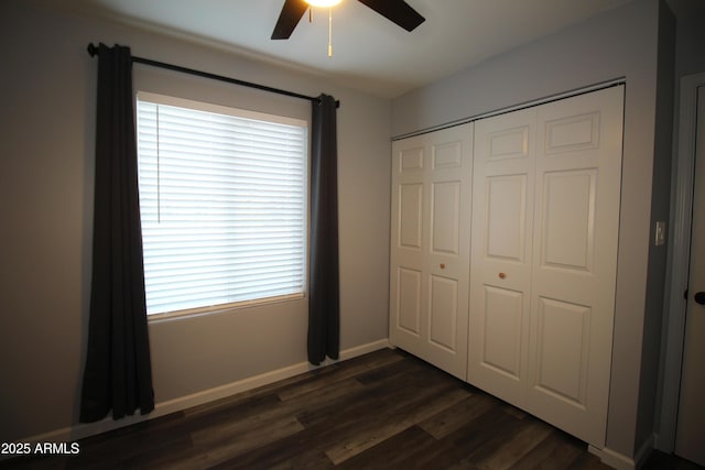 unfurnished bedroom with a closet, dark hardwood / wood-style floors, and ceiling fan