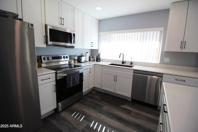 kitchen with a sink, stainless steel appliances, dark wood finished floors, and light countertops